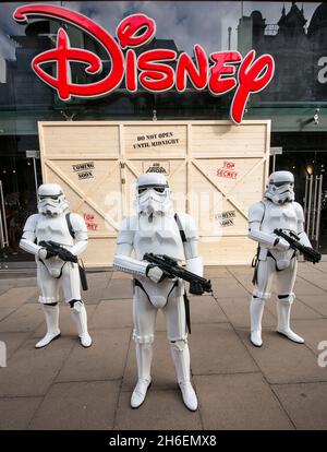 Stormtroopers und R2-D2 schlossen sich einem jungen Star Wars-Fan an, der als Prinzessin Leia Daisy im Alter von 8 Jahren im Disney Store in der Oxford Street gekleidet war, um den finalen Countdown bis Mitternacht zu beginnen, als die mit Spannung erwartete Star Wars: The Force Awakens-Produktlinie am 4. September auf den Markt kommt. Stockfoto