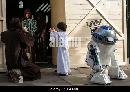 Stormtroopers und R2-D2 schlossen sich einem jungen Star Wars-Fan an, der als Prinzessin Leia Daisy im Alter von 8 Jahren im Disney Store in der Oxford Street gekleidet war, um den finalen Countdown bis Mitternacht zu beginnen, als die mit Spannung erwartete Star Wars: The Force Awakens-Produktlinie am 4. September auf den Markt kommt. Stockfoto