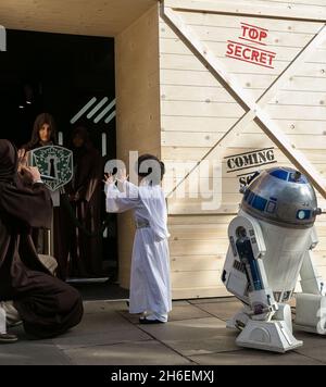 Stormtroopers und R2-D2 schlossen sich einem jungen Star Wars-Fan an, der als Prinzessin Leia Daisy im Alter von 8 Jahren im Disney Store in der Oxford Street gekleidet war, um den finalen Countdown bis Mitternacht zu beginnen, als die mit Spannung erwartete Star Wars: The Force Awakens-Produktlinie am 4. September auf den Markt kommt. Stockfoto