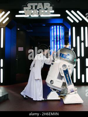 Stormtroopers und R2-D2 schlossen sich einem jungen Star Wars-Fan an, der als Prinzessin Leia Daisy im Alter von 8 Jahren im Disney Store in der Oxford Street gekleidet war, um den finalen Countdown bis Mitternacht zu beginnen, als die mit Spannung erwartete Star Wars: The Force Awakens-Produktlinie am 4. September auf den Markt kommt. Stockfoto