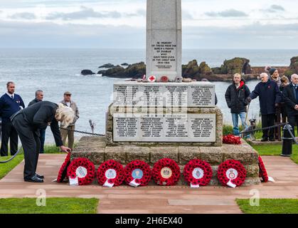Mann legt Mohnkranz am Kriegsdenkmal bei der Gedenkfeier zum Gedenktag, Dunbar, East Lothian, Schottland, Großbritannien Stockfoto