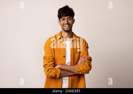 Selbstbewusster Mann aus dem Nahen Osten in lässiger Pose auf Grau Stockfoto