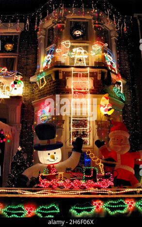 Anfang Dezember morgen leuchten die Familien bereits weihnachtlich. Die Dekorationen auf diesem Haus in East London kommt komplett mit einem aufblasbaren santa, blinkenden Zug und ein Zeichen, das die Tage bis weihnachten zählt. Stockfoto