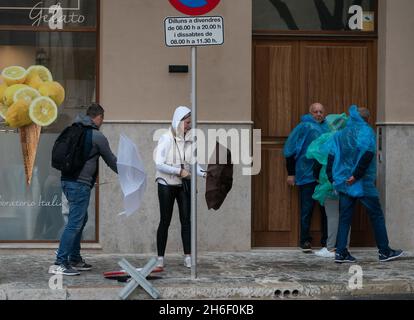 Touristen in Palma, Mallorca, ertragen Regen und Windböen bis zu 40 mph heute, als Großbritannien weiterhin eine Hitzewelle genießt Stockfoto