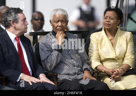 Nelson Mandela (Mitte) wird von seiner Frau Graca Machel (rechts) und dem britischen Premierminister Gordon Brown (links) bei der Enthüllung einer Bronzestatue seiner Person auf dem Parliament Square in London zu Ehren seines und vieler anderer Kämpfe gegen die Apartheid begleitet. Stockfoto