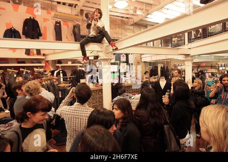 Leadsänger Dave Human von der Rockgruppe A.Human sorgte gestern Abend für Chaos, indem sie die Metallstrahlen der Küste erklommen, als sie einen einzigen kostenlosen Gig in Urban Outfitters, Covent Garden, im Zentrum von London spielten. Stockfoto