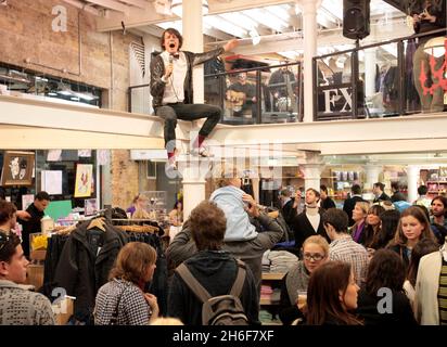 Leadsänger Dave Human von der Rockgruppe A.Human sorgte gestern Abend für Chaos, indem sie die Metallstrahlen der Küste erklommen, als sie einen einzigen kostenlosen Gig in Urban Outfitters, Covent Garden, im Zentrum von London spielten. Stockfoto