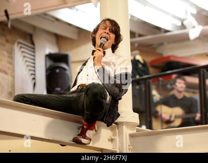 Leadsänger Dave Human von der Rockgruppe A.Human sorgte gestern Abend für Chaos, indem sie die Metallstrahlen der Küste erklommen, als sie einen einzigen kostenlosen Gig in Urban Outfitters, Covent Garden, im Zentrum von London spielten. Stockfoto