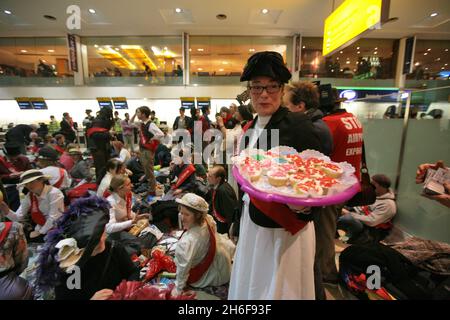 Im Terminal 1 des Flughafens Heathrow fand ein Protest gegen eine dritte Start- und Landebahn statt. Hunderte von Demonstranten kamen in edwardianischem Kleid mit Esskrümmen an, um ein „Abendessen bei den Inlandsabfahrten“ zu genießen. Stockfoto