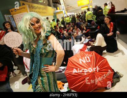 Im Terminal 1 des Flughafens Heathrow fand ein Protest gegen eine dritte Start- und Landebahn statt. Hunderte von Demonstranten kamen in edwardianischem Kleid mit Esskrümmen an, um ein „Abendessen bei den Inlandsabfahrten“ zu genießen. Stockfoto