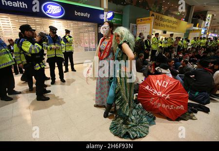 Im Terminal 1 des Flughafens Heathrow fand ein Protest gegen eine dritte Start- und Landebahn statt. Hunderte von Demonstranten kamen in edwardianischem Kleid mit Esskrümmen an, um ein „Abendessen bei den Inlandsabfahrten“ zu genießen. Stockfoto