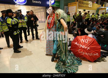 Im Terminal 1 des Flughafens Heathrow fand ein Protest gegen eine dritte Start- und Landebahn statt. Hunderte von Demonstranten kamen in edwardianischem Kleid mit Esskrümmen an, um ein „Abendessen bei den Inlandsabfahrten“ zu genießen. Stockfoto