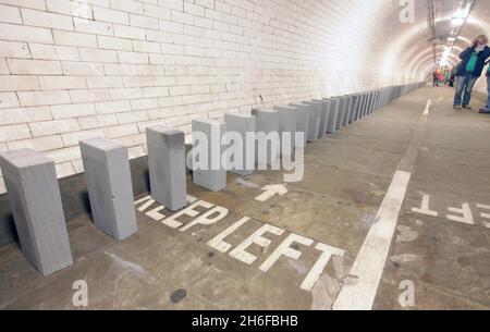 Dominosteine im Fußtunnel unter der themse von Island Gardens nach Greenwich als Teil einer 20 Meilen langen riesigen Domino-Rallye aus Windblöcken, die sich heute durch die fünf Bezirke der Olympischen Spiele 2012 in London erstreckte. 50,000 BREEZE-Blöcke wurden wie eine Reihe von Dominosteinen aufgestellt, wobei das Umstürzen der Blöcke am Nachmittag begann und 6 Stunden dauerte, bis es in einem großen Finale in der Dämmerung abgeschlossen wurde. Die Strecke führt durch Parks, Schulplätze, Wasserwege, Brücken und Unterführungen. Stockfoto