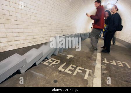 Dominosteine im Fußtunnel unter der themse von Island Gardens nach Greenwich als Teil einer 20 Meilen langen riesigen Domino-Rallye aus Windblöcken, die sich heute durch die fünf Bezirke der Olympischen Spiele 2012 in London erstreckte. 50,000 BREEZE-Blöcke wurden wie eine Reihe von Dominosteinen aufgestellt, wobei das Umstürzen der Blöcke am Nachmittag begann und 6 Stunden dauerte, bis es in einem großen Finale in der Dämmerung abgeschlossen wurde. Die Strecke führt durch Parks, Schulplätze, Wasserwege, Brücken und Unterführungen. Stockfoto