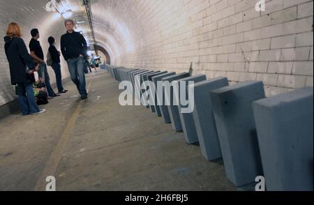 Dominosteine im Fußtunnel unter der themse von Island Gardens nach Greenwich als Teil einer 20 Meilen langen riesigen Domino-Rallye aus Windblöcken, die sich heute durch die fünf Bezirke der Olympischen Spiele 2012 in London erstreckte. 50,000 BREEZE-Blöcke wurden wie eine Reihe von Dominosteinen aufgestellt, wobei das Umstürzen der Blöcke am Nachmittag begann und 6 Stunden dauerte, bis es in einem großen Finale in der Dämmerung abgeschlossen wurde. Die Strecke führt durch Parks, Schulplätze, Wasserwege, Brücken und Unterführungen. Stockfoto