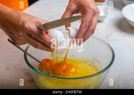 Gib drei Eier in eine Tasse mit Zutaten Stockfoto