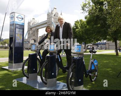 Der Bürgermeister von London, Boris Johnson, fährt mit Deanna Oppenheimer von Barclays ein Barclays-Fahrrad zur Fahrradvermietung auf einer Fotozelle im Potters Field Park im Zentrum von London, wo Barclays als offizieller Sponsor des neuen Londoner Fahrradverleihprogramms angekündigt wurde, das im Juli startet. Stockfoto