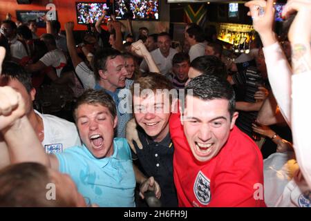 Englische Fußballfans feiern heute Nachmittag im Sports Cafe im Londoner Haymarket Englands erstes Tor Stockfoto