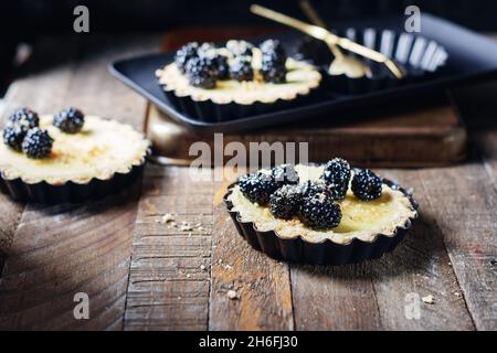 Frisch gebackene Brombeeren- und Vanillepudding-Torten. Stockfoto