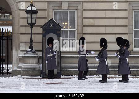 Wachen, die heute Morgen vor dem Buckingham Palace im Schnee im Zentrum Londons abgebildet sind Stockfoto