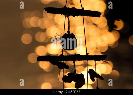 Wind, der mit Muscheln am Meer in der Abenddämmerung auf einem verschwommenen Hintergrund erklingen wird Stockfoto