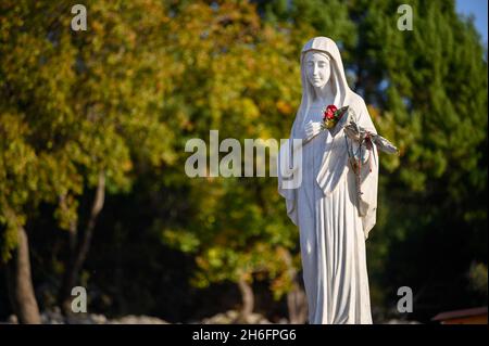 Statue der seligen Jungfrau Maria auf dem Berg Podbrdo, dem Erscheinungsberg mit Blick auf das Dorf Medjugorje in Bosnien und Herzegowina. Stockfoto