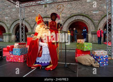 ENSCHEDE, NIEDERLANDE - 13. NOV 2021: Der niederländische Weihnachtsmann namens Sinterklaas kommt in die Stadt. In diesem Jahr sitzt er auf einem Stuhl davor Stockfoto