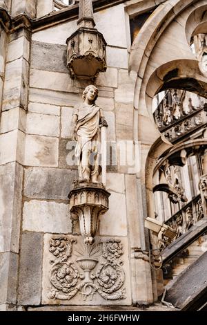 Statue eines Mannes mit einem Schwert auf einem Sockel an der Fassade des Doms. Mailand, Italien Stockfoto