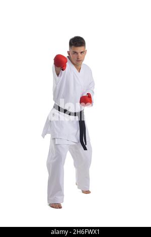 In voller Länge Porträt eines Karate Mann Übung isoliert auf weißem Hintergrund macht einen Treffer Stockfoto