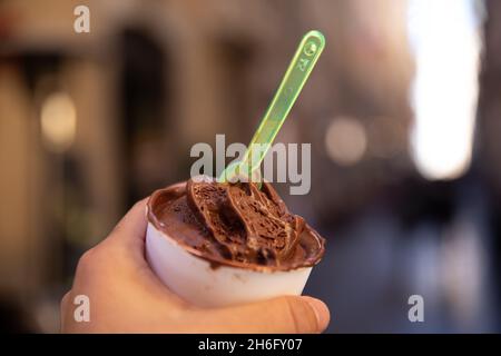 Hand hält ein Schokoladeneis in einer Wanne in der Roma Street. Stockfoto