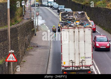 Ein Radfahrer kam dicht an einem Müllrecycling-LKW in der Nähe von Halifax, Calderdale, West Yorkshire vorbei.nahe Pässe sind nicht nur wirklich einschüchternd, sondern auch gefährlich: Die Polizei führt ein "Passieren zu nah am Radfahrer" als einen Beitrag zu erstaunlichen 25% der schweren Kollisionen zwischen Radfahrern und großen Fahrzeugen an. Gleichzeitig wissen wir, dass 62 % der Menschen im Vereinigten Königreich das Radfahren auf den Straßen als ‘zu gefährlich“ betrachten. Wenn wir sicherere Straßen für Radfahrer und mehr Menschen mit dem Fahrrad wollen, ist es absolut wichtig, die enge Durchfahrt zu beenden. Stockfoto