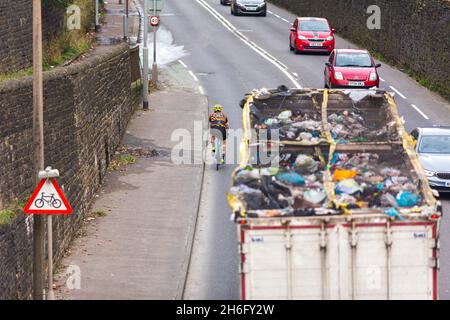 Ein Radfahrer kam dicht an einem Müllrecycling-LKW in der Nähe von Halifax, Calderdale, West Yorkshire vorbei.nahe Pässe sind nicht nur wirklich einschüchternd, sondern auch gefährlich: Die Polizei führt ein "Passieren zu nah am Radfahrer" als einen Beitrag zu erstaunlichen 25% der schweren Kollisionen zwischen Radfahrern und großen Fahrzeugen an. Gleichzeitig wissen wir, dass 62 % der Menschen im Vereinigten Königreich das Radfahren auf den Straßen als ‘zu gefährlich“ betrachten. Wenn wir sicherere Straßen für Radfahrer und mehr Menschen mit dem Fahrrad wollen, ist es absolut wichtig, die enge Durchfahrt zu beenden. Stockfoto