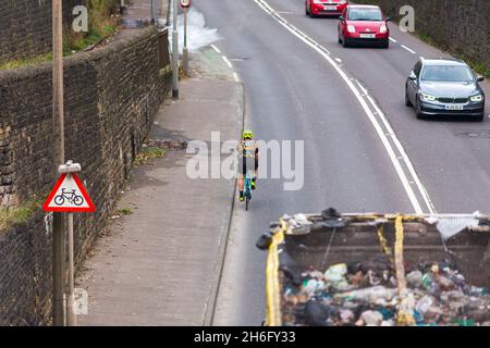 Ein Radfahrer kam dicht an einem Müllrecycling-LKW in der Nähe von Halifax, Calderdale, West Yorkshire vorbei.nahe Pässe sind nicht nur wirklich einschüchternd, sondern auch gefährlich: Die Polizei führt ein "Passieren zu nah am Radfahrer" als einen Beitrag zu erstaunlichen 25% der schweren Kollisionen zwischen Radfahrern und großen Fahrzeugen an. Gleichzeitig wissen wir, dass 62 % der Menschen im Vereinigten Königreich das Radfahren auf den Straßen als ‘zu gefährlich“ betrachten. Wenn wir sicherere Straßen für Radfahrer und mehr Menschen mit dem Fahrrad wollen, ist es absolut wichtig, die enge Durchfahrt zu beenden. Stockfoto