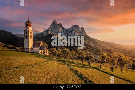 Seis am Schlern, Italien - wunderschöner Sonnenuntergang und idyllische Bergkulisse in den italienischen Dolomiten mit St. Valentin Kirche und dem berühmten Schlern mit Stockfoto