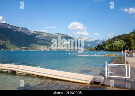 Kristallklares Wasser des Sees Annecy mit einer Kulisse von Bergen, Annecy Frankreich Stockfoto