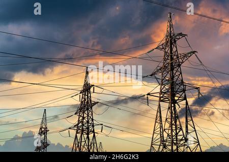 Stromleitungen gegen den dramatischen Himmel. Energietransport und mangelndes Energiekonzept Stockfoto