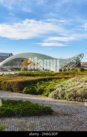 Tiflis, Georgien - 24. Oktober 2021: Der Rike Park in der georgischen Hauptstadt mit der Brücke des Friedens, bogenförmige Fußgängerbrücke über die Kura Stockfoto