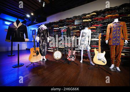 New York, USA. November 2021. (L-R) Elvis Presley Jacke und Bühne gespielt 1972 Martin D-28 Akustikgitarre, ein Whitney Houston Kleid, Jerry Garcia's Banjo, George Michael Jacke, eine handsignierte Eddie Van Halen Gitarre, ein Amy Winehouse Kleid, David Gilmour's Vintage '57 Reissue Fender Stratocaster Stage gespielt auf Pink Floyd Touren, Und ein Whitney-Houston-Kleid, das während Juliens Auction Icons & Rock „N“ Roll-Presseinterview auf dem Times Square Hard Rock in New York, NY, am 15. November 2021, ausgestellt wurde. (Foto von Anthony Behar/Sipa USA) Quelle: SIPA USA/Alamy Live News Stockfoto