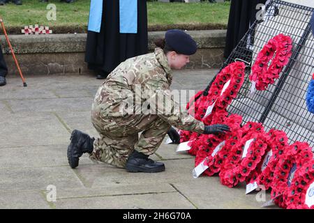 Troon Remembrance Parade, South Ayrshire, Schottland, Großbritannien. 14 Nov 2021 Jugendgruppen, Angehörige der Streitkräfte, Veteranen, Politiker und Gemeindevertreter marschierten zum Kriegsdenkmal Centaph in Troon, um ihre Achtung zu zollen und Kränze zu legen. Erste vollständige Parade nach Covid 19 Lockdowns. Eine junge Kaderin der Armee legt ihren Kranz nieder Stockfoto