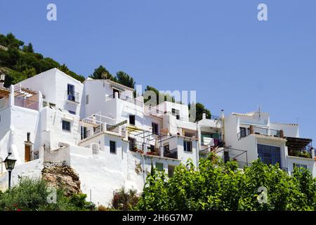 Wunderschönes Frigiliana Dorf, Spanien weiß getünchte traditionelle Häuser auf einem steilen Hügel dramatische Landschaft mit Blick auf die Altstadt Blauer Himmel und Polizist Stockfoto