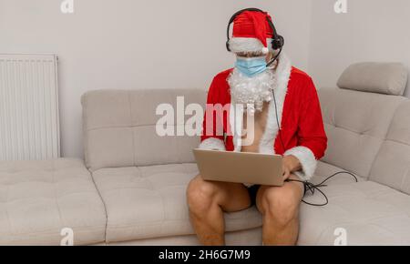 Gekleidet als Weihnachtsmann mit Laptop ohne Hose Stockfoto