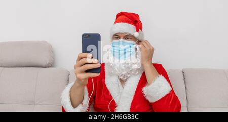 Als Weihnachtsmann gekleidet, der über eine Videokonferenz spricht Stockfoto