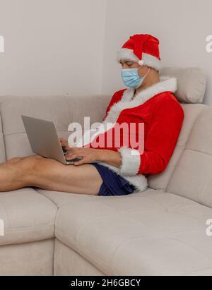 Gekleidet als Weihnachtsmann mit Laptop ohne Hose Stockfoto