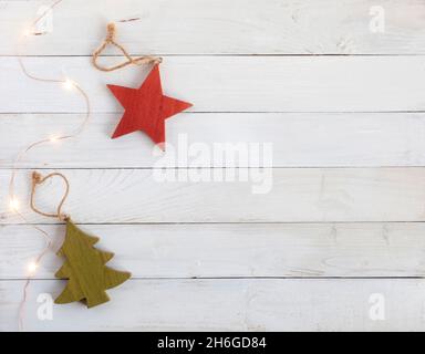 Neujahr Baumschmuck aus Holz und Girlande auf dem weißen Holzhintergrund, Draufsicht, Kopierraum Stockfoto