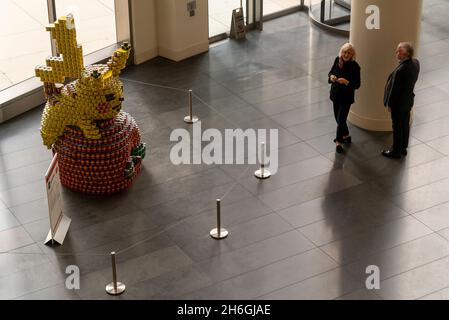 Besucher sehen, wie Pikachu beim jährlichen Canstruction Design Competition in New York, der am Sonntag, dem 7. November 2021, im Brookfield Place in New York zu sehen ist, einen Happen aus dem Big Apple von Microdesk nimmt. Architektur- und Designunternehmen beteiligen sich an der Planung und dem Bau riesiger Strukturen aus Dosen von Lebensmitteln. Die Dosen werden am Ende der Ausstellung an City Harvest gespendet. Über 100,000 Dosen Lebensmittel werden gesammelt und zur Versorgung der Bedürftigen in Suppenküchen und Speisekammern verwendet. (© Richard B. Levine) Stockfoto