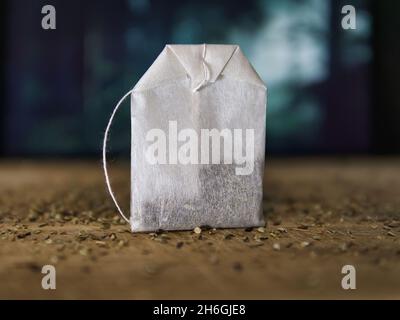 Gesunder Teebeutel auf Holzplatte mit Kräutern in der Natur Stockfoto