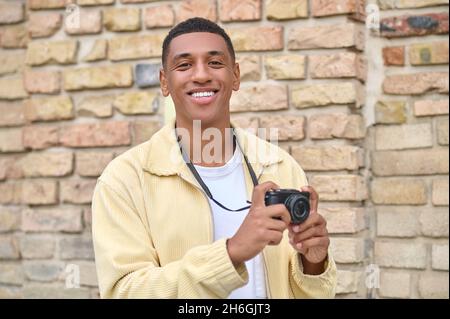 Kopfschuss eines jungen dunkelhäutigen Mannes in beiger Jacke Stockfoto