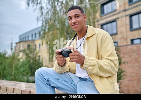 Fotograf in beigefarbener Kleidung, der die Aufnahmen überprüft Stockfoto