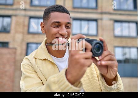 Fotograf in beigefarbener Kleidung, der die Aufnahmen überprüft Stockfoto