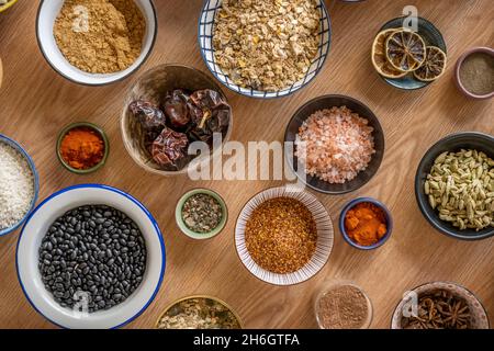 Set von Schüsseln mit Zutaten für Fusion Food Rezepte. Schwarze Bohnen, Sternanise, Reis, Chia und Kakao, Sternanise, Schwarzer Pfeffer, Panela Stockfoto